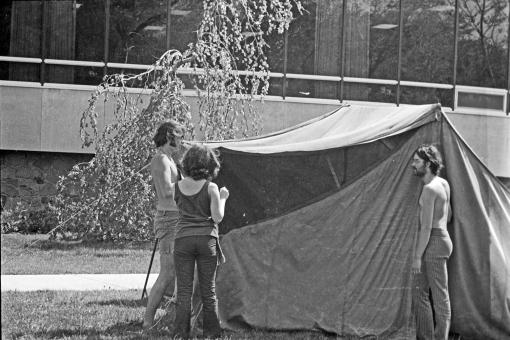 Three people standing by a tent in Peoples' Park in 1970